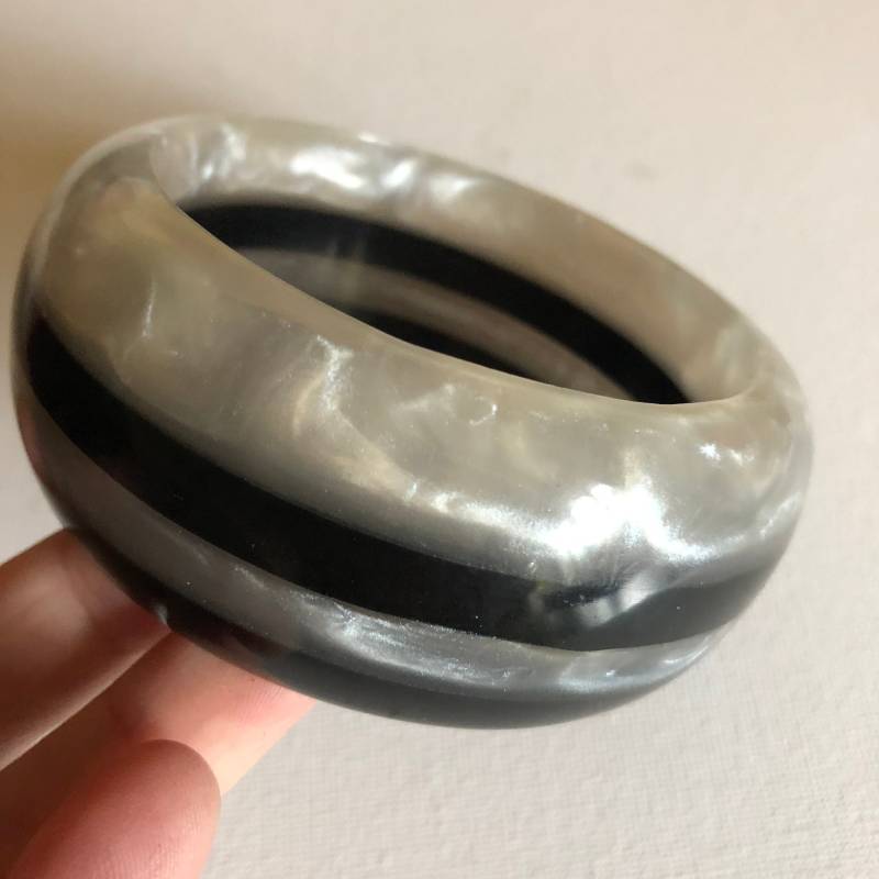 Armreif - Ein Knalliges, Schwarz-Marmoriertes, Weiß Gestreiftes Kunststoffarmband Im Retro-Design Armreif - Ein Knalliges, Schwarz-Marmoriertes, Weiß Gestreiftes Kunststoffarmband Im Retro-Design von 20thCenturyStuff