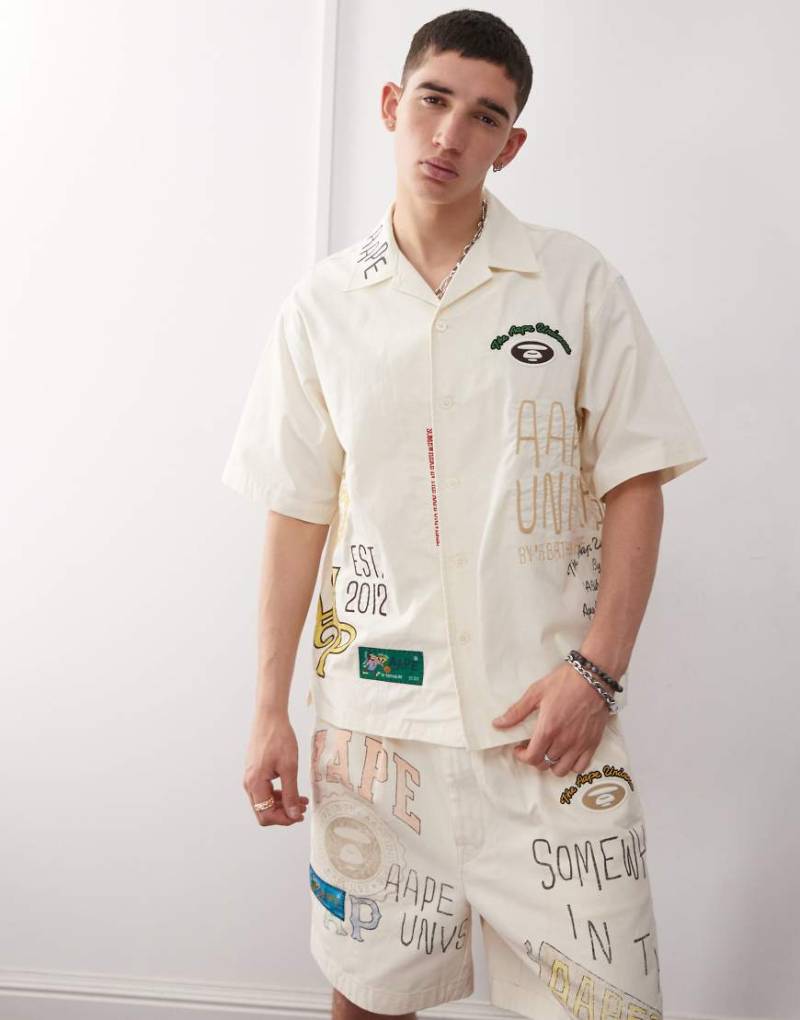 AAPE BY A BATHING APE - Kurzärmliges Hemd in Beige mit bunten College-Logos-Neutral von AAPE BY A BATHING APE®