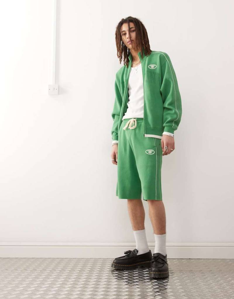 AAPE BY A BATHING APE - Strick-Shorts in lockerer Passform in Grün mit College-Logo, Kombiteil von AAPE BY A BATHING APE®