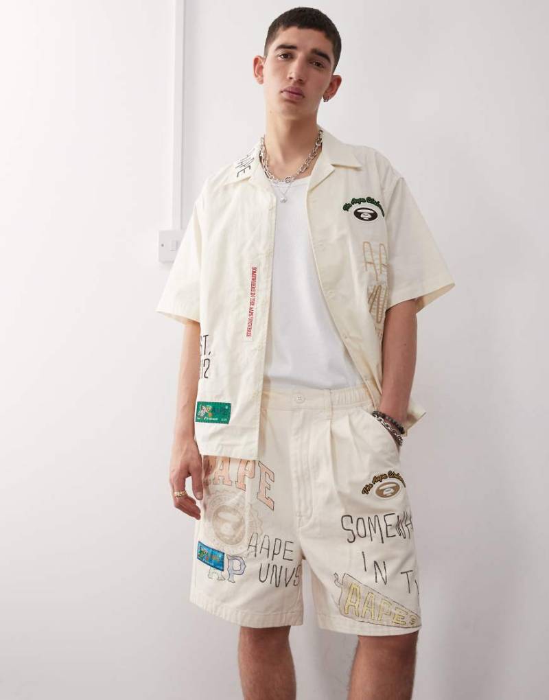 AAPE BY A BATHING APE - Shorts in Beige mit bunten College-Logos-Neutral von AAPE BY A BATHING APE®
