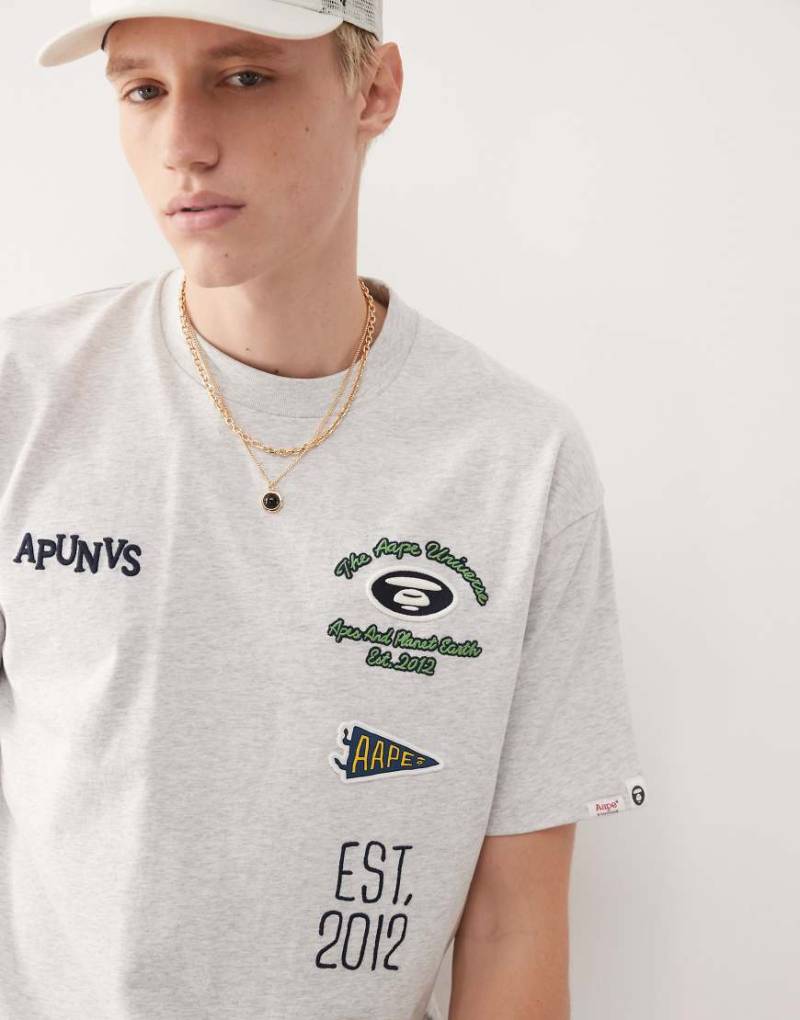 Aape by A Bathing Ape - Kastiges T-Shirt in Grau mit mehreren platzierten College-Stickereien von AAPE BY A BATHING APE®