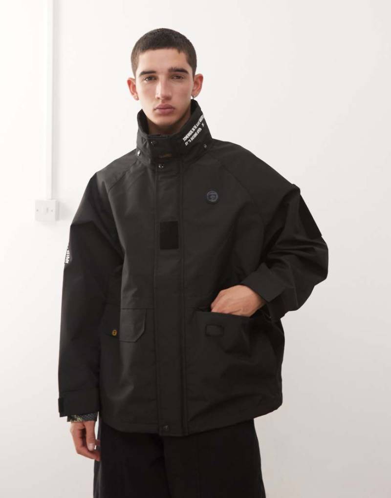 Aape by A Bathing Ape - Wasserabweisende Regenjacke in Schwarz mit platziertem Logo-Print von AAPE BY A BATHING APE®