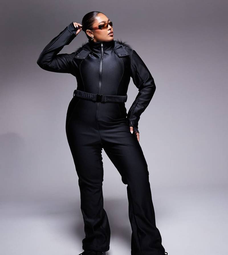 4505 Curve - Ski - Skianzug in glänzendem Schwarz mit Gürtel, ausgestelltem schmalem Bein und Kapuze mit Kunstpelzbesatz von ASOS 4505 Ski & Snow