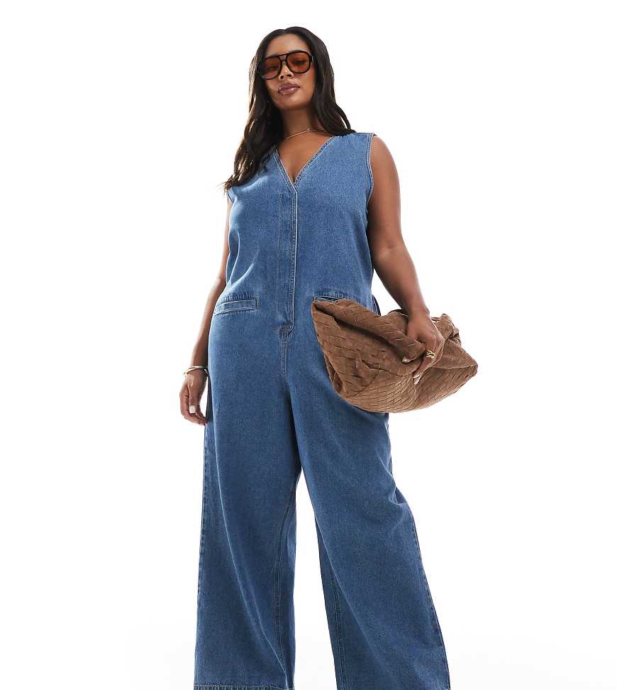 ASOS DESIGN Curve - Ärmelloser Jeans-Jumpsuit in mittelblauer Waschung mit lockerem Schnitt von ASOS Curve