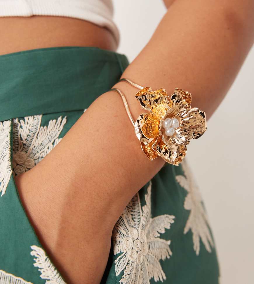 ASOS DESIGN Curve - Goldfarbenes Armband mit auffälligem Blumendetail und Kunstperlen ASOS DESIGN Curve - Goldfarbenes Armband mit auffälligem Blumendetail und Kunstperlen von ASOS Curve