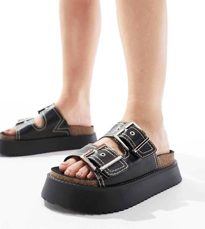 ASOS DESIGN - Firecracker - Flache Sandalen in Schwarz mit zwei Riemen und Fußbett, weite Passform ASOS DESIGN - Firecracker - Flache Sandalen in Schwarz mit zwei Riemen und Fußbett, weite Passform von ASOS DESIGN Wide Fit