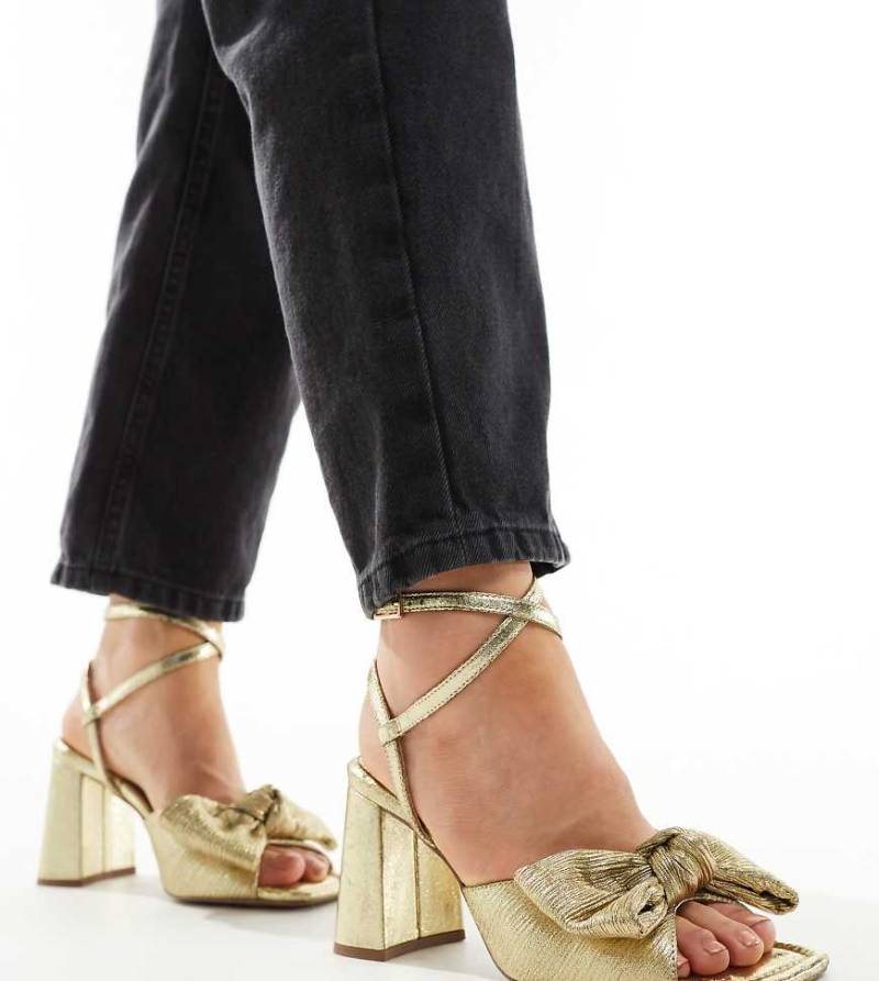 ASOS DESIGN Wide Fit - Hitched - Sandalen in Gold mit mittelhohem Blockabsatz und Schleifendetail, weite Passform-Goldfarben von ASOS DESIGN Wide Fit