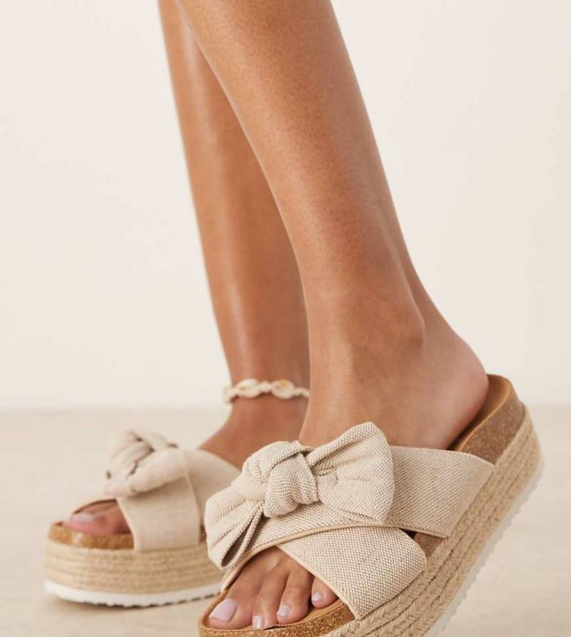 ASOS DESIGN Wide Fit - Thankful - Sandalen aus natürlichem Material mit Schleifendetail und flacher Plateausohle, weite Passform-Neutral von ASOS DESIGN Wide Fit