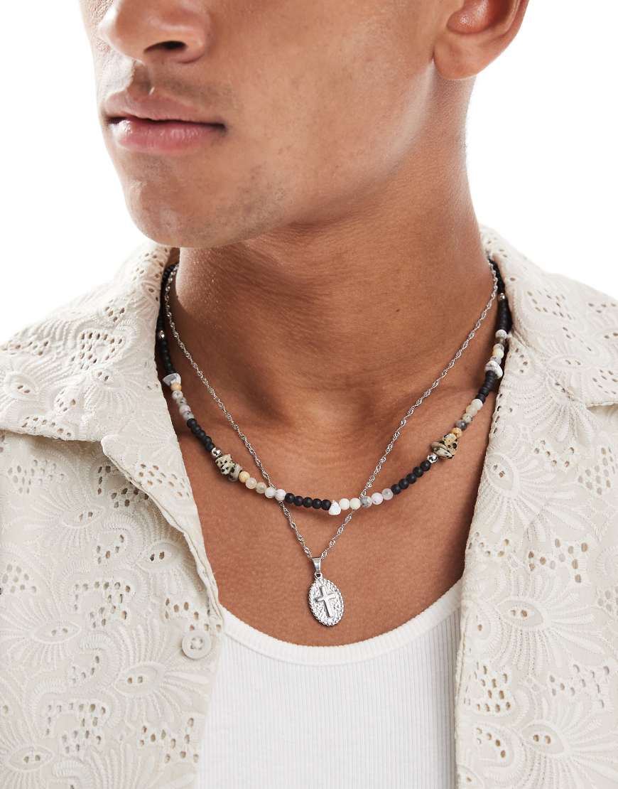 ASOS DESIGN - 2er-Pack Festival-Halskette in Silber und Schwarz mit Halbedelsteinperlen und Münzanhänger mit Kreuz von ASOS DESIGN