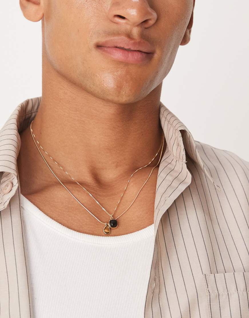 ASOS DESIGN - 2er-Pack goldfarbene Halsketten mit Onyx- und Tigeraugen-Anhängern ASOS DESIGN - 2er-Pack goldfarbene Halsketten mit Onyx- und Tigeraugen-Anhängern von ASOS DESIGN