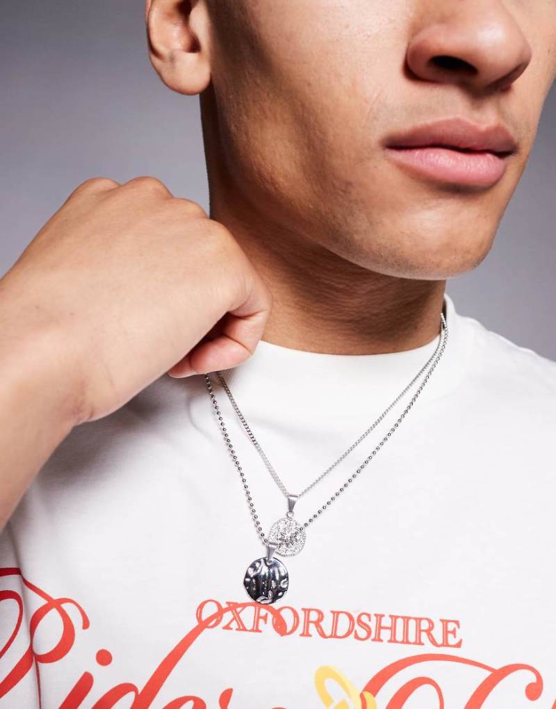 ASOS DESIGN - Silberfarbene Halsketten im 2er-Pack aus wasserfestem Edelstahl mit Anhängern in geschmolzenem, gehämmertem Design von ASOS DESIGN
