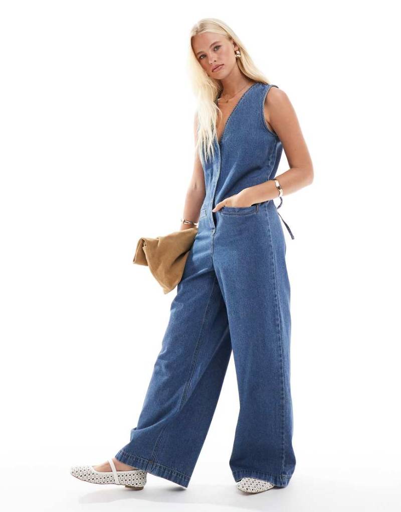 ASOS DESIGN - Ärmelloser Jeans-Jumpsuit in mittelblauer Waschung mit lockerem Schnitt von ASOS DESIGN