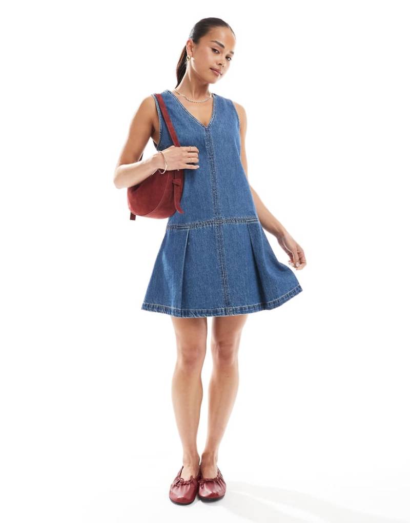 ASOS DESIGN - Ärmelloses Minikleid aus Denim in mittelblauer Waschung mit tiefer Taille mit Falten von ASOS DESIGN