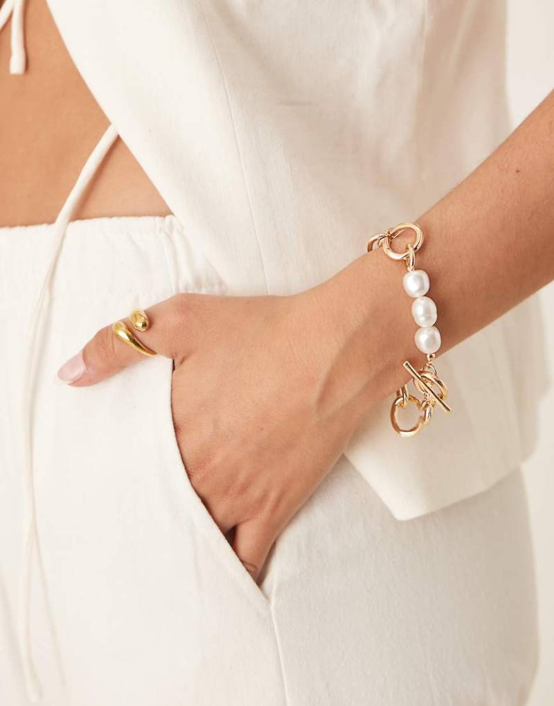 ASOS DESIGN - Armband in Goldoptik mit Kettendesign, T-Steg und Kunstperlen-Goldfarben von ASOS DESIGN