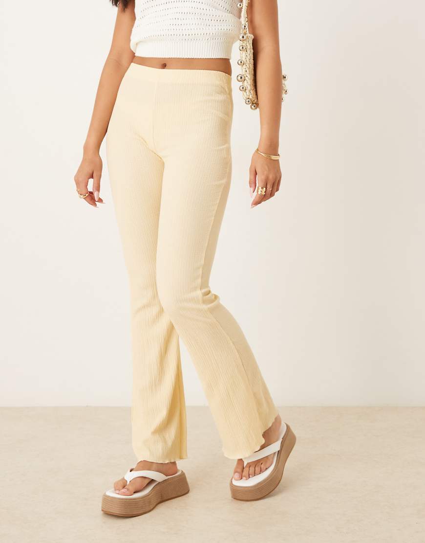 ASOS DESIGN - Ausgestellte Hose in sanftem Gelb mit Knitterstruktur von ASOS DESIGN