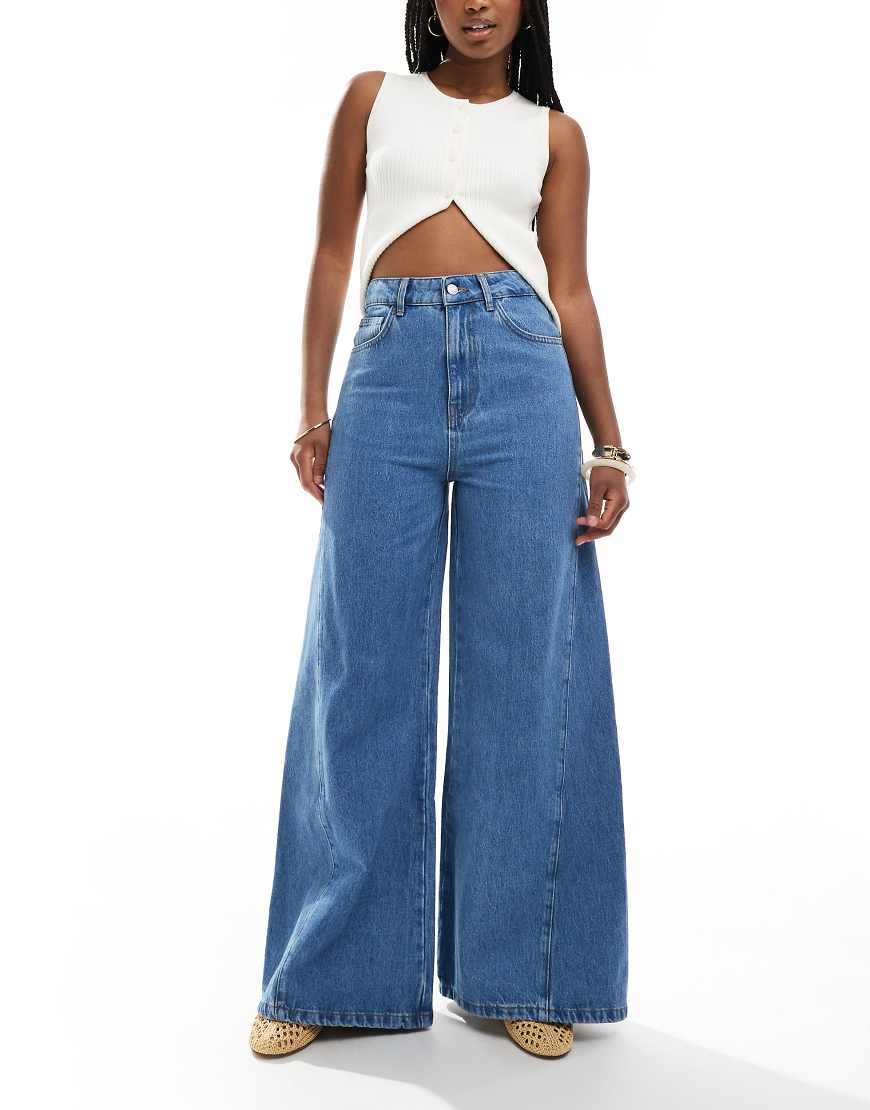 ASOS DESIGN - Ausgestellte Jeans in mittelblauer Waschung mit Godet-Einsätzen ASOS DESIGN - Ausgestellte Jeans in mittelblauer Waschung mit Godet-Einsätzen von ASOS DESIGN