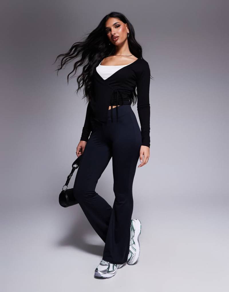 ASOS DESIGN - Ausgestellte Leggings in Schwarz mit überkreuztem Detail und V-Design von ASOS DESIGN