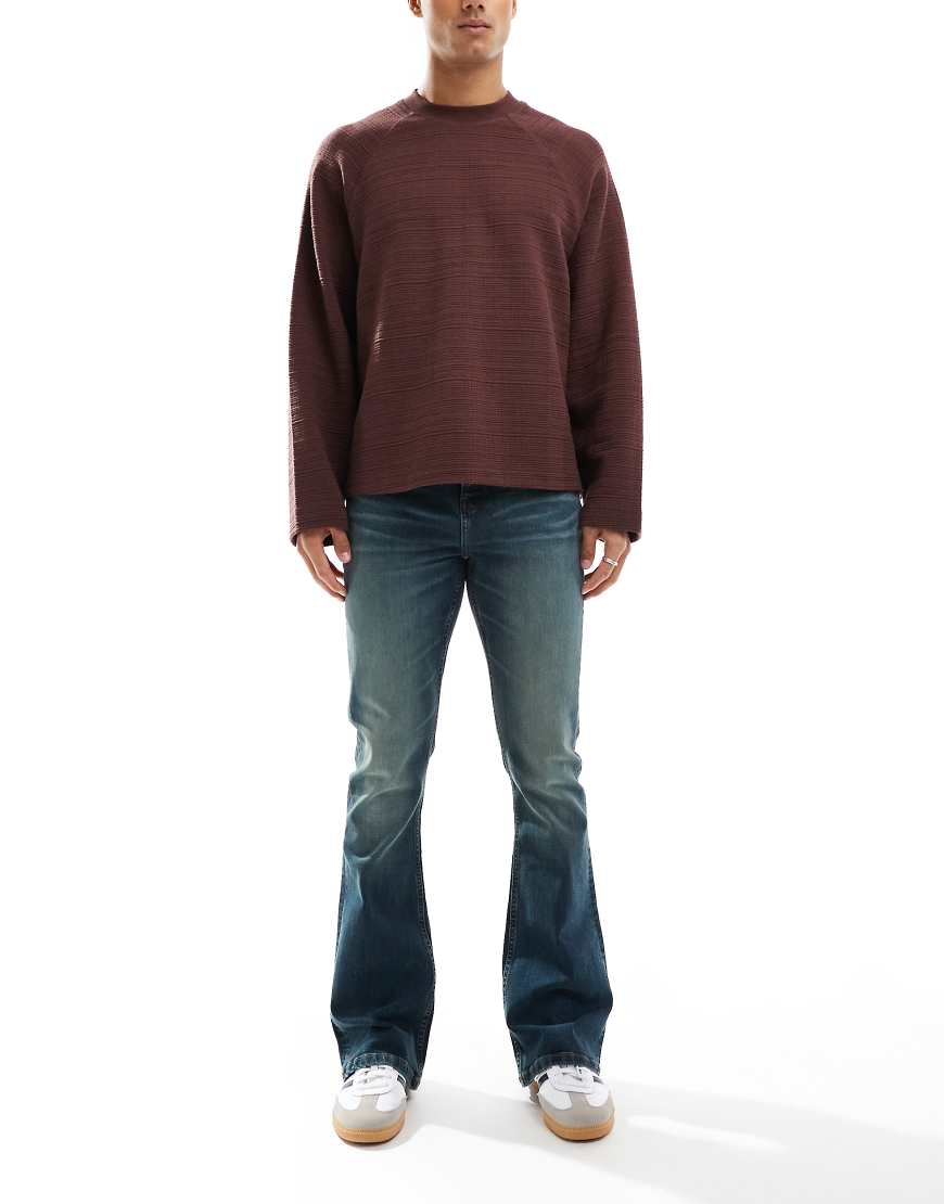 ASOS DESIGN - Ausgestellte Stretch-Jeans in Mittelblau mit grüner Tönung von ASOS DESIGN