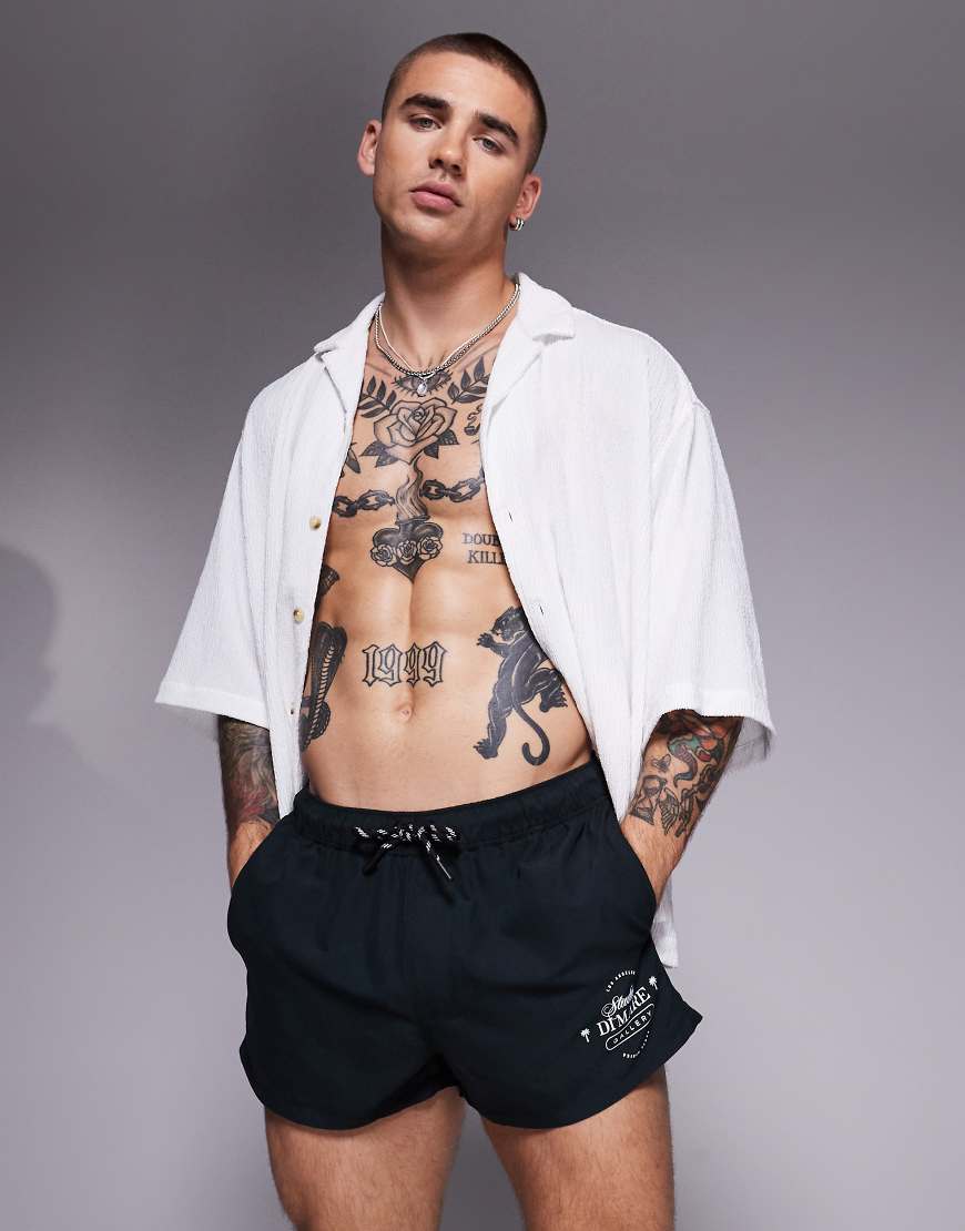 ASOS DESIGN - Badeshorts in Schwarz mit Print in Weiß und superkurzer Länge von ASOS DESIGN