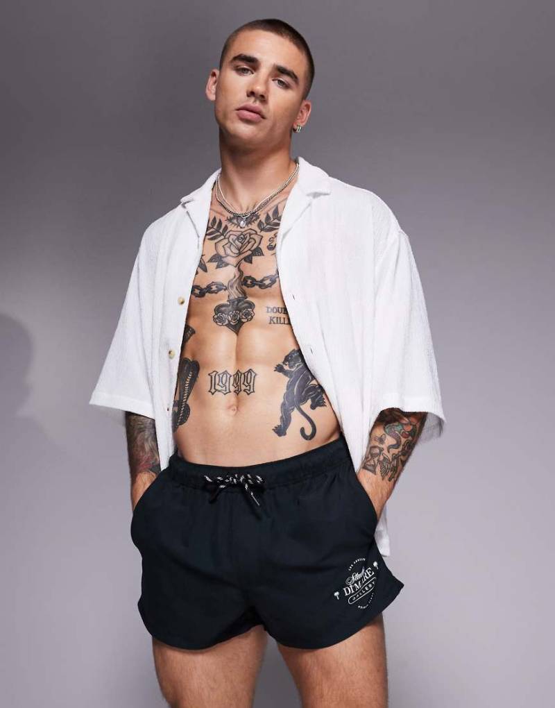ASOS DESIGN - Badeshorts in Schwarz mit Print in Weiß und superkurzer Länge von ASOS DESIGN