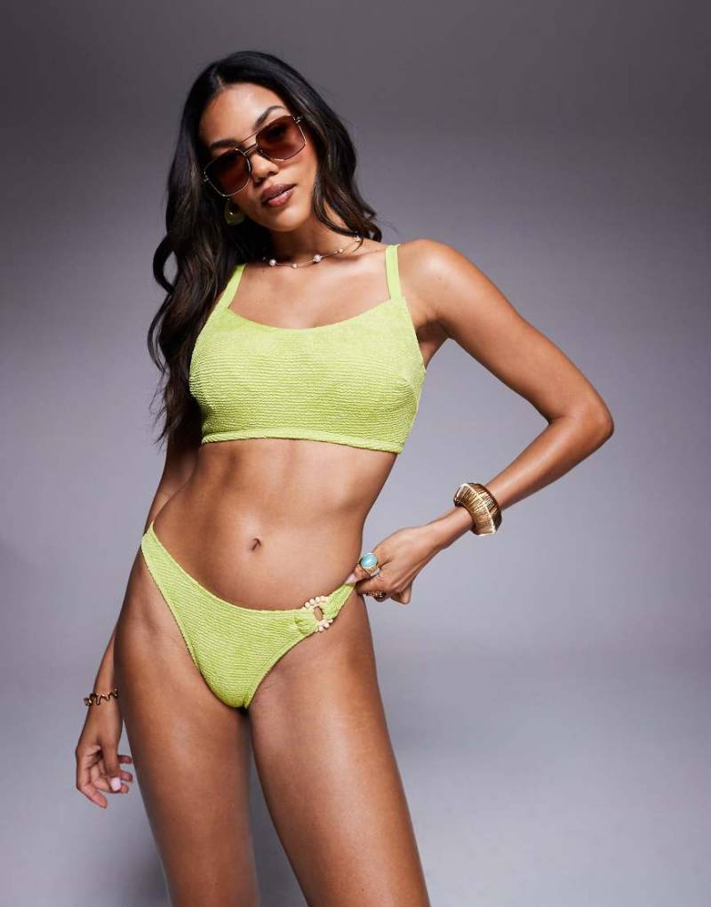 ASOS DESIGN - Bella - Bikinihose in hellem Chartreuse-Grün mit Strukturmuster, hohem Beinausschnitt und Ringdetail mit Zierperlen von ASOS DESIGN