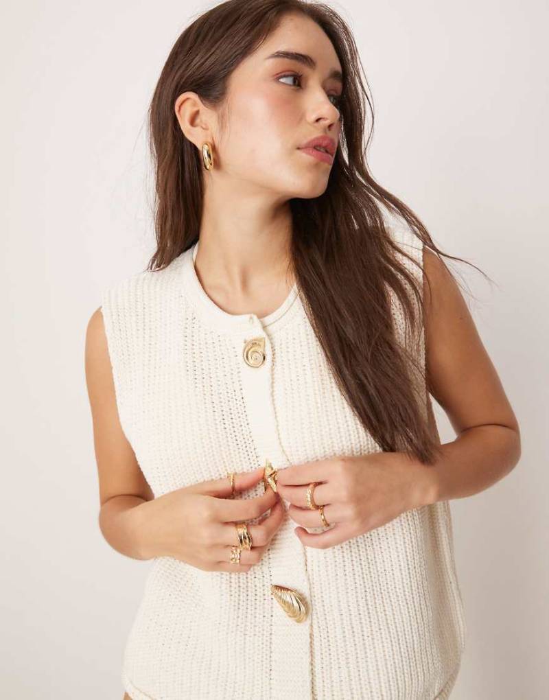 ASOS DESIGN - Boxy Fit Strick-Weste in Weiß mit verschiedenen, muschelförmigen Knöpfen von ASOS DESIGN