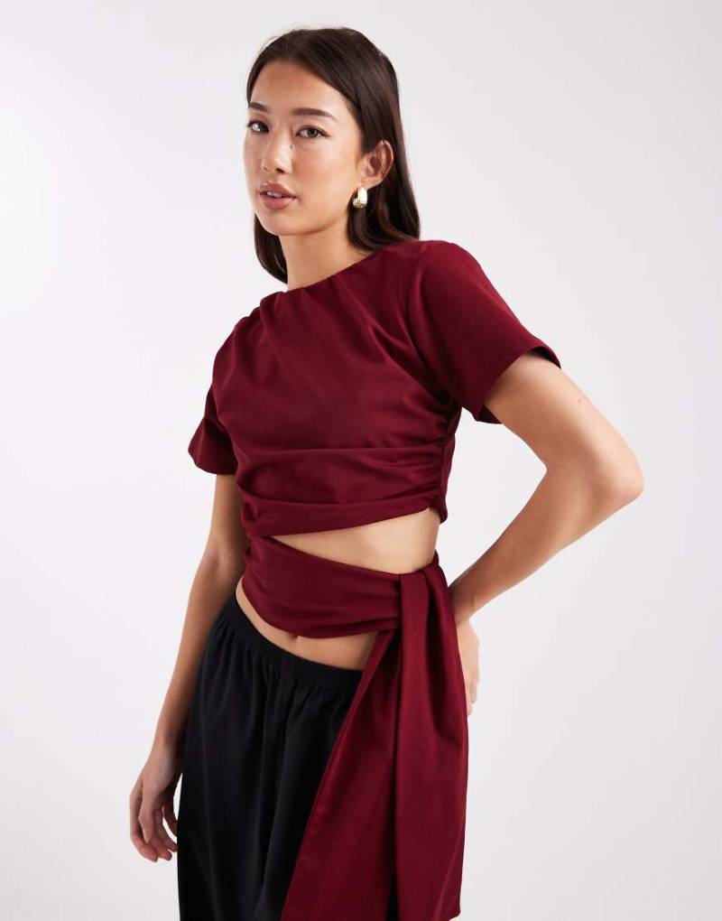 ASOS DESIGN - Cropped-T-Shirt in Burgunderrot mit Schulterpolstern und seitlichem Bindeband an der Taille von ASOS DESIGN