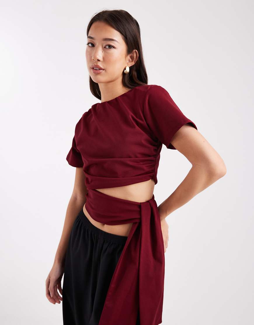 ASOS DESIGN - Cropped-T-Shirt in Burgunderrot mit Schulterpolstern und seitlichem Bindeband an der Taille von ASOS DESIGN