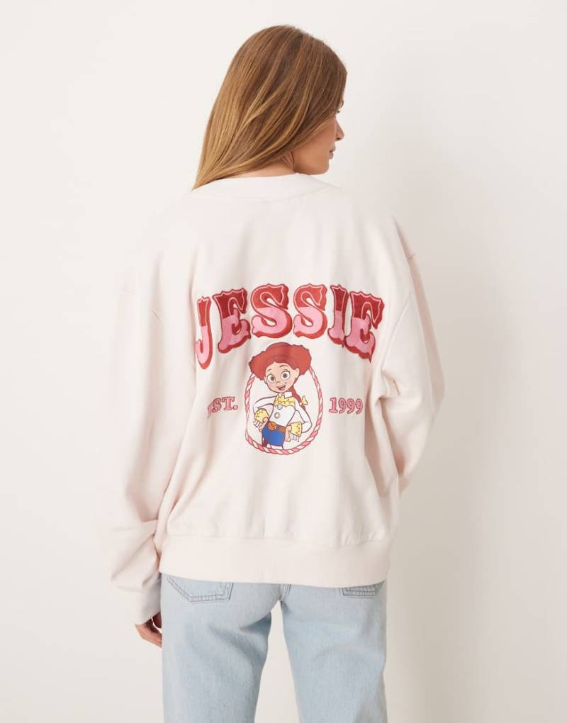 ASOS DESIGN - Disney Pixar - Oversize-Strickjacke in Rosa mit „Jessie Toy Story"-Print von ASOS DESIGN
