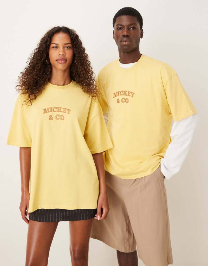 ASOS DESIGN - Disney - Unisex-T-Shirt in verwaschenem Gelb mit Oversize-Schnitt und „Mickey Mouse and Friends"-Westernprints von ASOS DESIGN