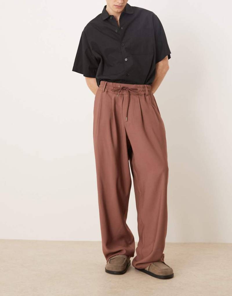 ASOS DESIGN - Elegante, locker geschnittene Hose in Braun mit breitem Bund und elastischer Taille ASOS DESIGN - Elegante, locker geschnittene Hose in Braun mit breitem Bund und elastischer Taille von ASOS DESIGN