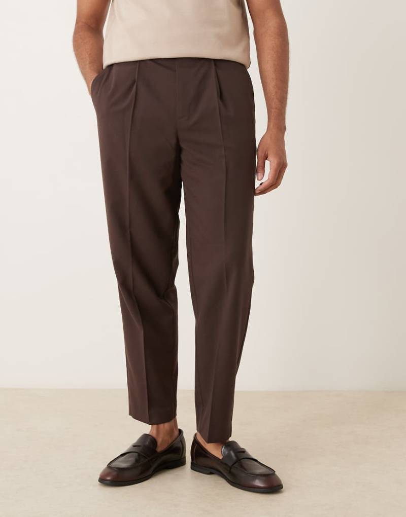 ASOS DESIGN - Elegante, schmal zulaufende Chino-Hose in Dunkelbraun mit Bundfalten vorne und lockerem Schnitt-Brown von ASOS DESIGN