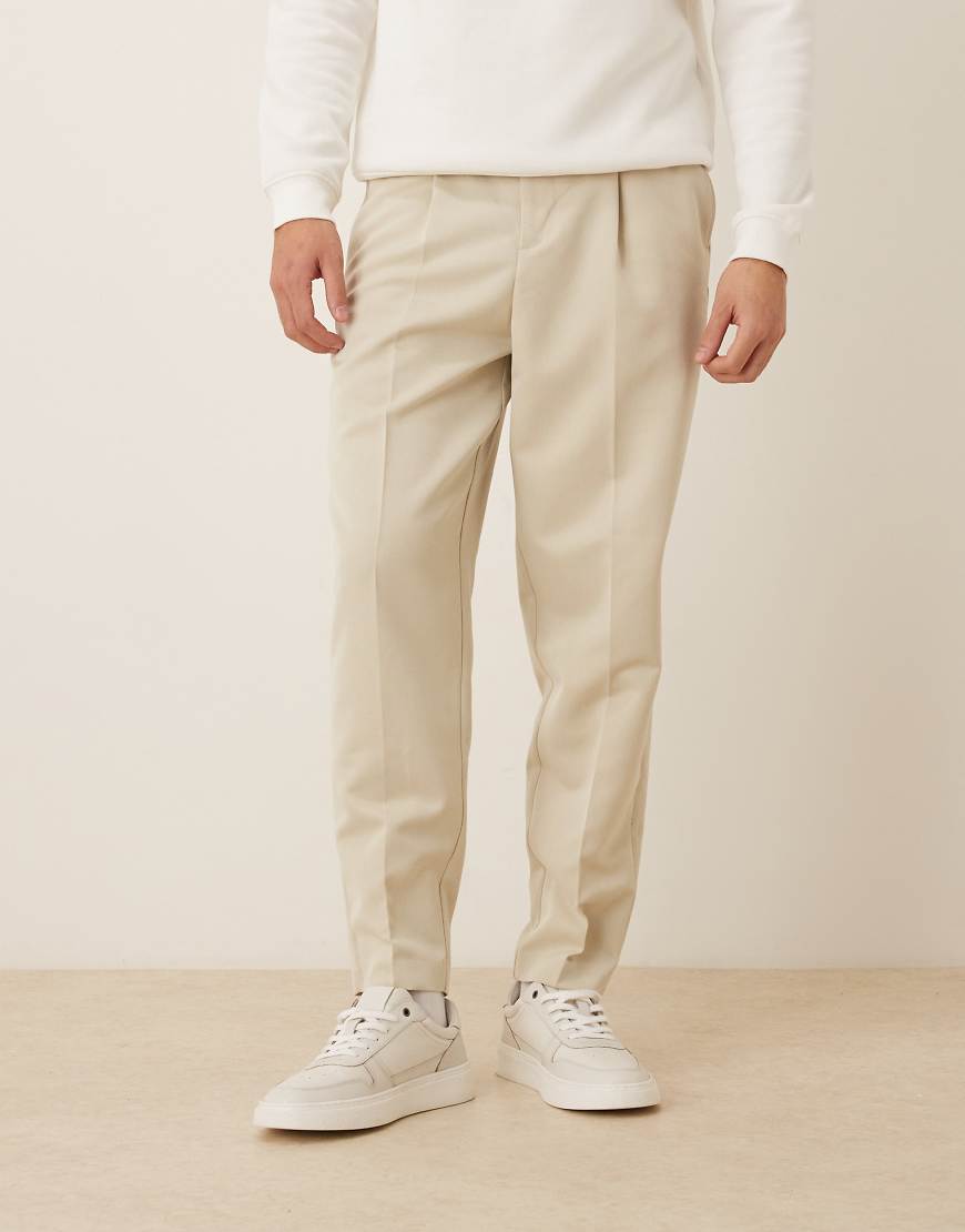 ASOS DESIGN - Elegante, schmal zulaufende Hose in Ecru mit lockerer Passform und Bundfalten-Weiß von ASOS DESIGN