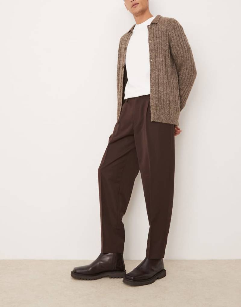 ASOS DESIGN - Elegante, schmal zulaufende Oversize-Hose in Braun mit Bundfalten von ASOS DESIGN