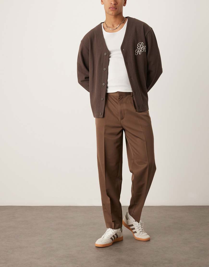 ASOS DESIGN - Elegante, schmal zulaufende Oversize-Hose in Braun mit Bundfalten ASOS DESIGN - Elegante, schmal zulaufende Oversize-Hose in Braun mit Bundfalten von ASOS DESIGN