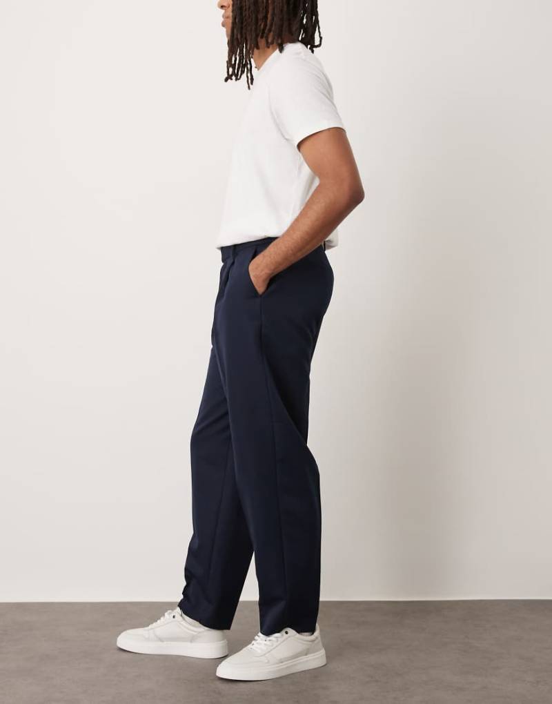 ASOS DESIGN - Elegante, schmal zulaufende Oversize-Hose in Marineblau mit Bundfalten ASOS DESIGN - Elegante, schmal zulaufende Oversize-Hose in Marineblau mit Bundfalten von ASOS DESIGN
