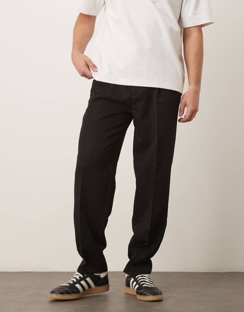 ASOS DESIGN - Elegante, schmal zulaufende Oversize-Hose in Schwarz mit Bundfalten von ASOS DESIGN
