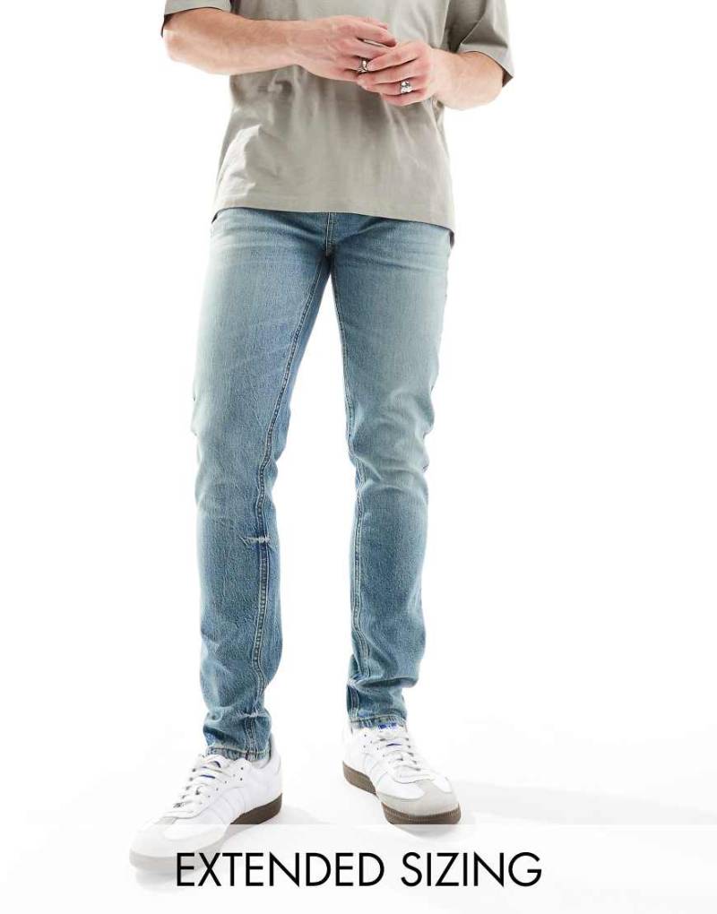 ASOS DESIGN - Eng geschnittene Jeans in getönter, mittlerer Vintage-Waschung-Blau von ASOS DESIGN