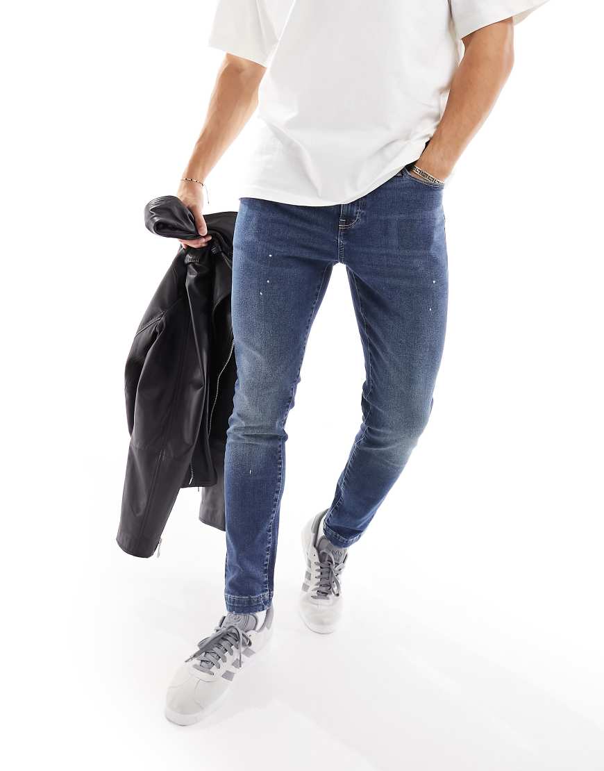 ASOS DESIGN - Eng geschnittene Jeans in mittelblauer Waschung mit Farbspritzer-Detail ASOS DESIGN - Eng geschnittene Jeans in mittelblauer Waschung mit Farbspritzer-Detail von ASOS DESIGN