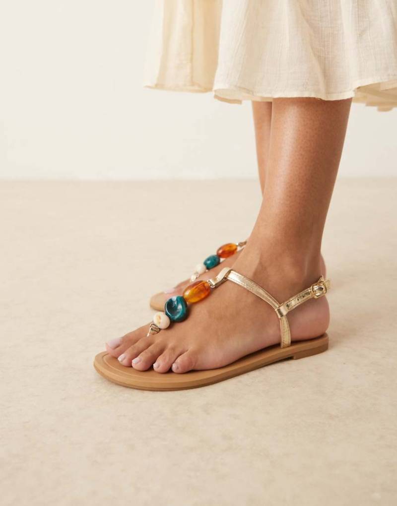 ASOS DESIGN - Feud - Flache Zehenstegsandalen in Gold mit Steinverzierung-Goldfarben von ASOS DESIGN