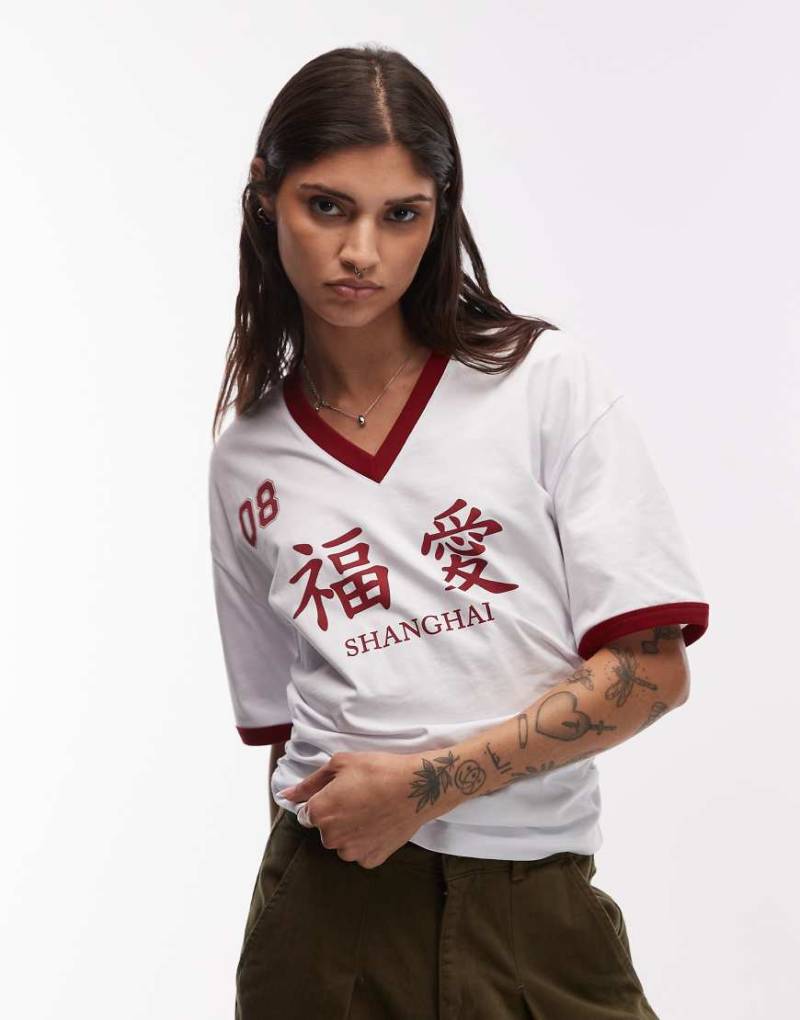 ASOS DESIGN - Fußball-T-Shirt mit Flammengarn-Struktur, V-Ausschnitt und „Shanghai"-Print-Bunt ASOS DESIGN - Fußball-T-Shirt mit Flammengarn-Struktur, V-Ausschnitt und „Shanghai"-Print-Bunt von ASOS DESIGN
