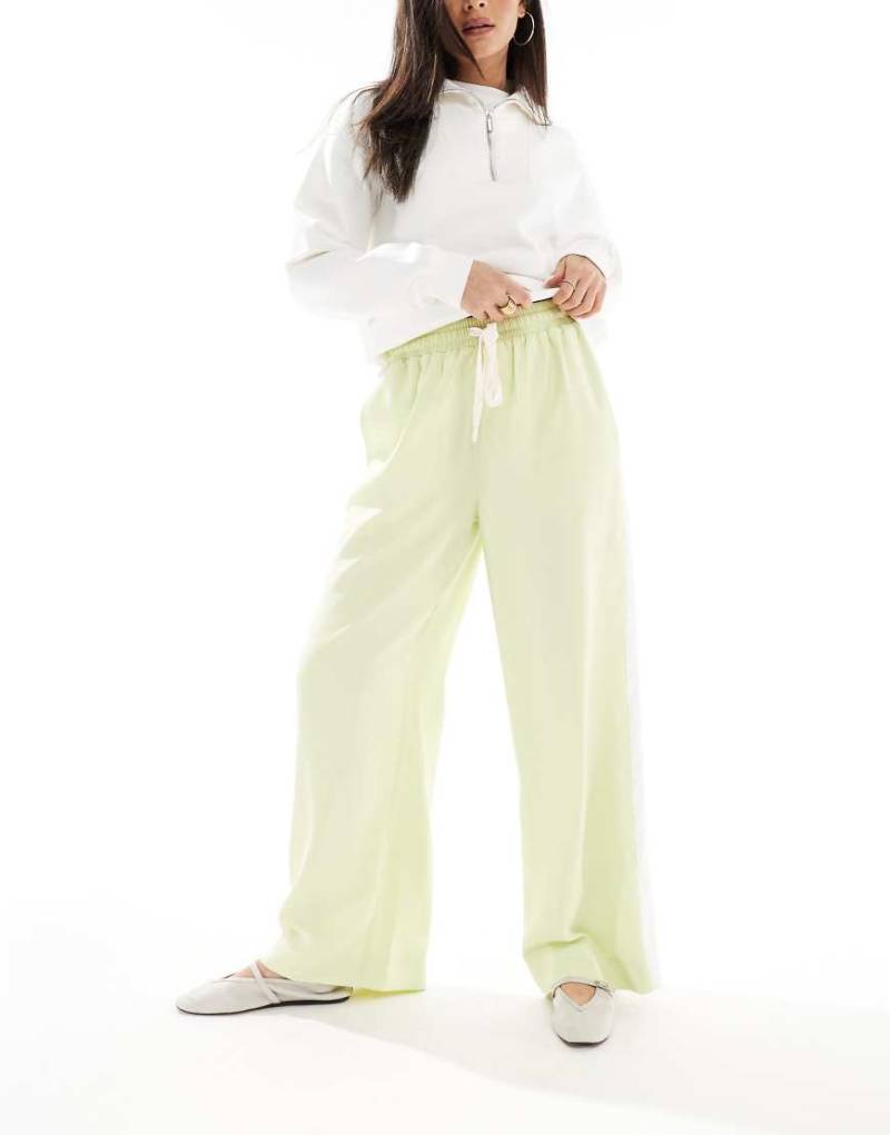 ASOS DESIGN - Gemusterte Schlupfhose in Limettengrün mit Bahn in Kontrastfarbe von ASOS DESIGN