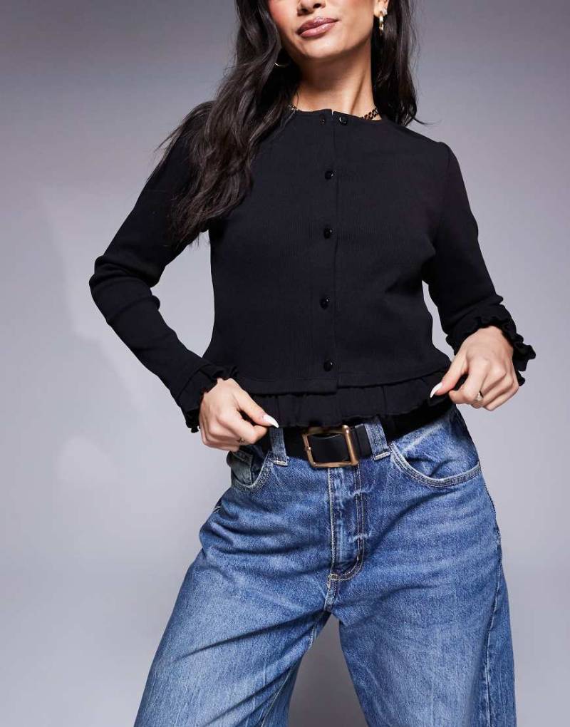 ASOS DESIGN - Gerippte, kurze Strickjacke in Schwarz mit Rüschen von ASOS DESIGN