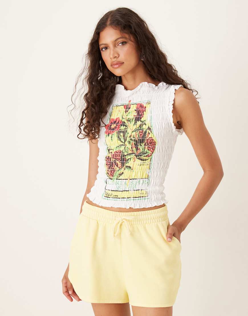 ASOS DESIGN - Gesmoktes T-Shirt in Weiß mit Granatapfel-Grafik ASOS DESIGN - Gesmoktes T-Shirt in Weiß mit Granatapfel-Grafik von ASOS DESIGN