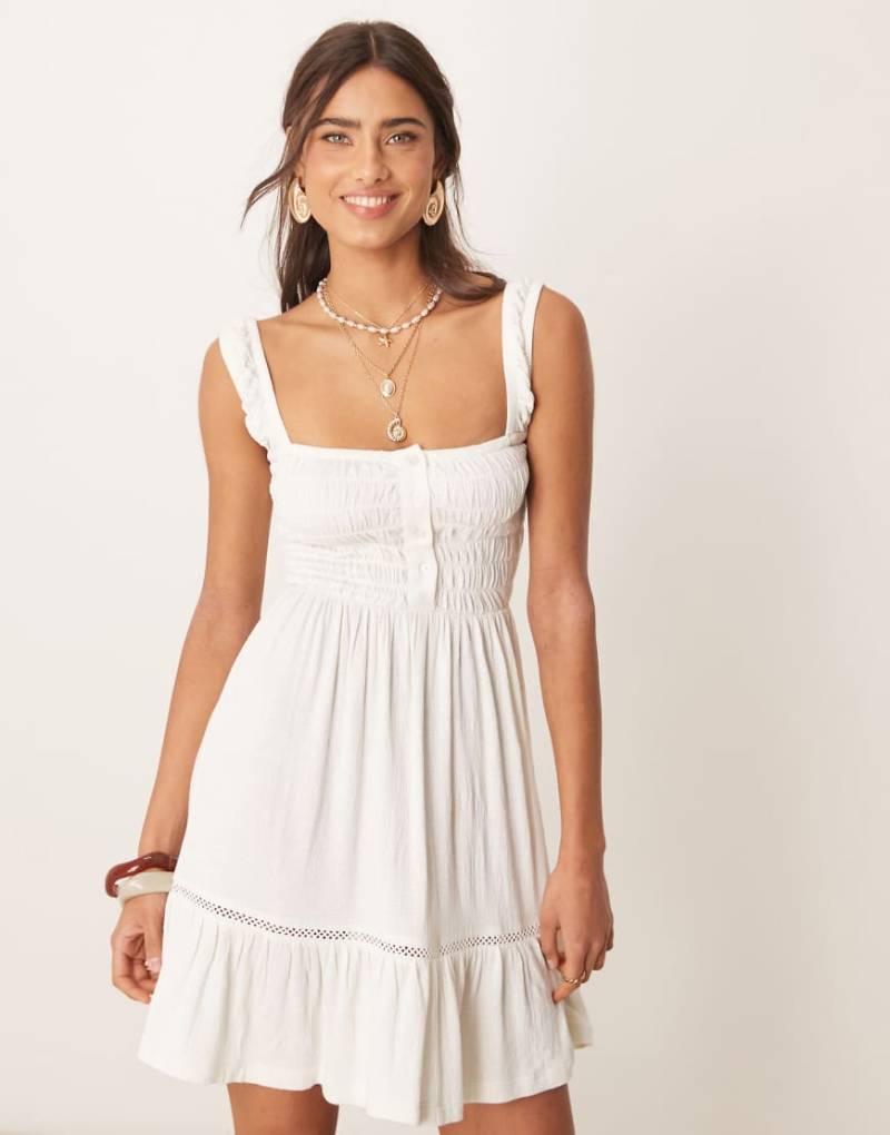 ASOS DESIGN - Gestuftes, gerafftes Minikleid in Weiß mit eckigem Ausschnitt und Spitzeneinsätzen von ASOS DESIGN