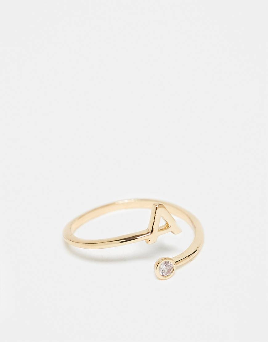 ASOS DESIGN - Goldfarbener Ring mit Wickeldesign, Zirkoniabesatz, „A"-Initiale und Geschenkbeutel von ASOS DESIGN