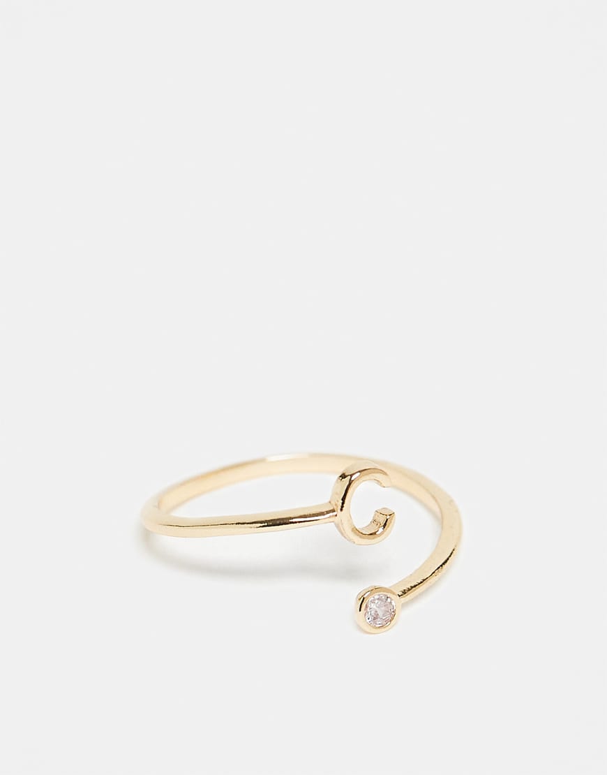 ASOS DESIGN - Goldfarbener Ring mit Wickeldesign, Zirkoniabesatz, „C"-Initiale und Geschenkbeutel von ASOS DESIGN