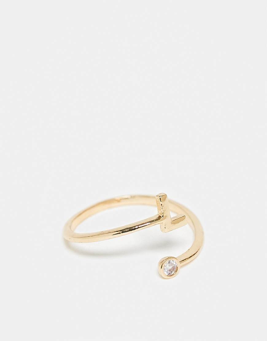 ASOS DESIGN - Goldfarbener Ring mit Wickeldesign, Zirkoniabesatz, „L"-Initiale und Geschenkbeutel von ASOS DESIGN
