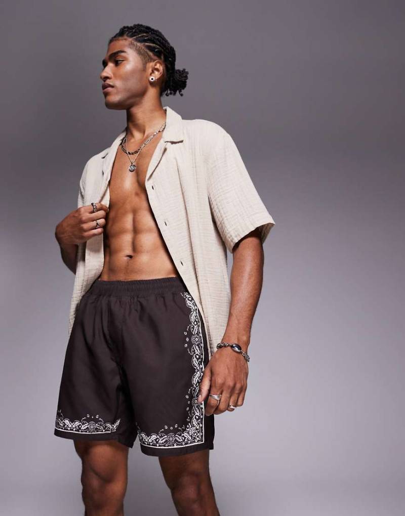 ASOS DESIGN - Halblange Badeshorts in Braun mit gemustertem Rand ASOS DESIGN - Halblange Badeshorts in Braun mit gemustertem Rand von ASOS DESIGN