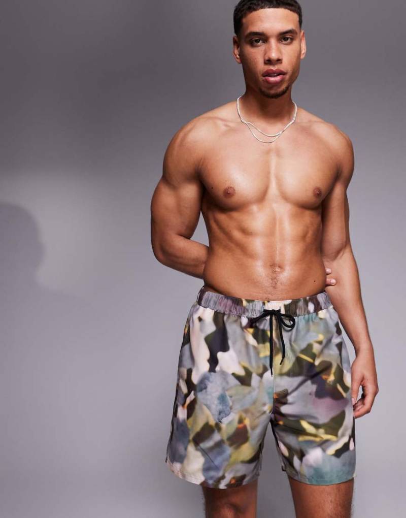 ASOS DESIGN - Halblange Badeshorts in Grün mit Military-Muster von ASOS DESIGN